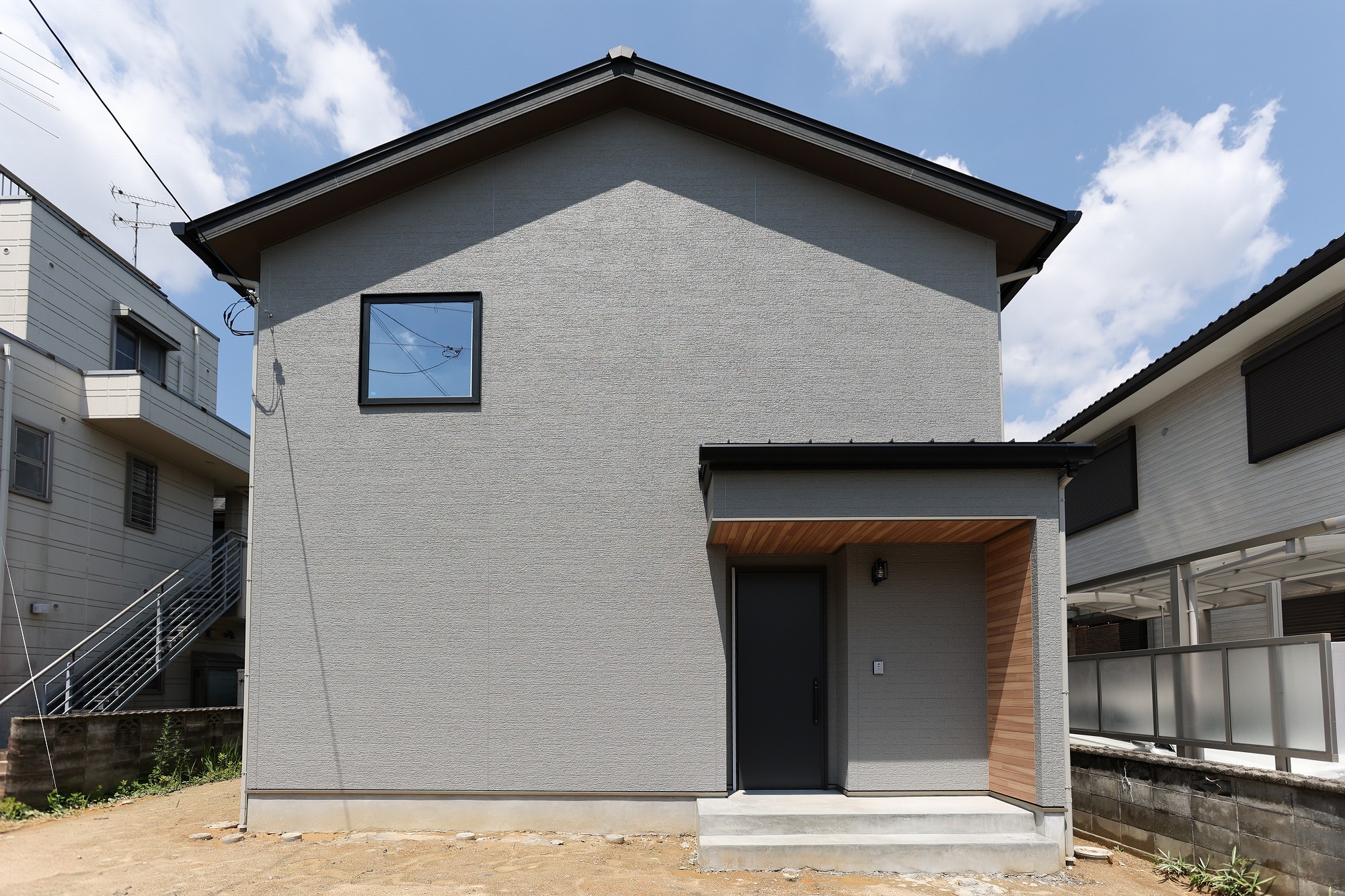 グレー×木目が織りなす洗練空間。ふたりでくつろぐ吹き抜けリビングの家
